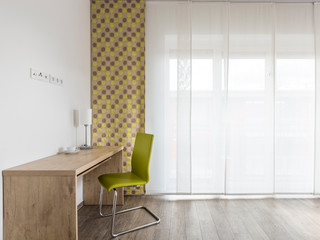 chair and table in a room in short-term apartment rental room interior. Upscale desk in European hotel suite or vacation apartment
