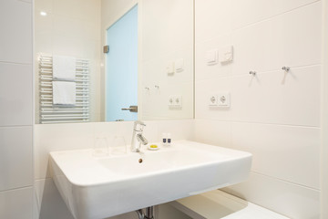 Naklejka na ściany i meble Sink in European vacation apartment or hotel interior, showing modern water faucet and accompanying amenities like soap, shampoo and conditioner or lotion