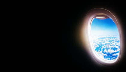 Black background with copy space with look of window seat frame of airplane flight see view of sunset clouds, airplane wing, ice mountains for luxury trip tourism travel transportation concept