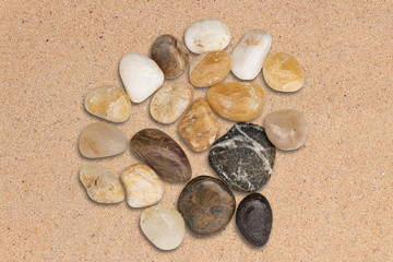 Fototapeta na wymiar Round pebble stones on beach sand. Top view