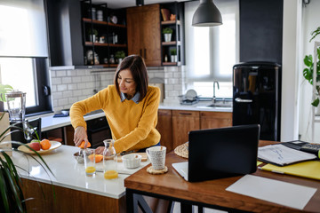 Young business entrepreneur woman working at home while having breakfast