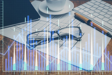 Financial chart hologram with glasses on the table background. Concept of business. Double exposure.