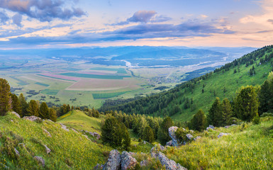 Over a spacious mountain valley. The sky in the light of sunrise. Mountains of Altai, Russia.