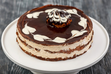 Dessert chocolate biscuit cake with cream, chocolate mirror glaze