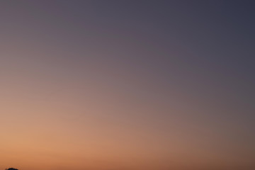 Heaven at early morning with copy space. Smooth orange blue gradient of dawn sky.Sunset, sunrise backdrop.Predawn clear sky with orange horizon and blue atmosphere.  Background of beginning of day.