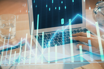Multi exposure of market chart with man working on computer on background. Concept of financial...