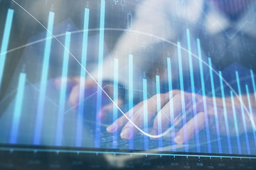 Forex graph with businessman working on computer in office on background. Concept of hardworking. Multi exposure.