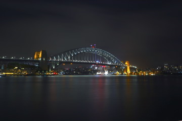 Obraz na płótnie Canvas Sydney Harbour Bridge illuminating the harbour and circular quay with vibrant colourful lights at midnight in NSW Australia