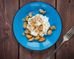 Breakfast with seafood and rice on a blue plate standing on a table