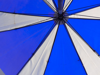 The blue and white umbrella was photographed from the bottom of the umbrella and the iron was the handle of the umbrella.