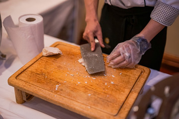 An image of a chef using a knife to chop boiled chicken.