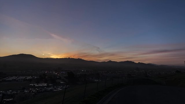 Time-Lapse of a beautiful sky and sunrise on a small valley town in the early morning 