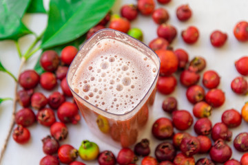 Fruits, leaves and red Araça juice (Psidium cattleianum) on a light background