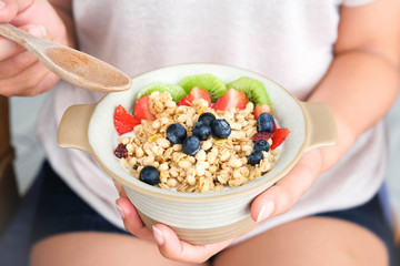Hand of woman holding bowl of fresh strawberry and yogurt .Concept of healthy diet and weight control