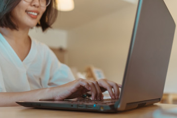 Happy woman smile while using laptop to work study on work desk with clean nature background background. Business, financial, trade stock maket and social network.