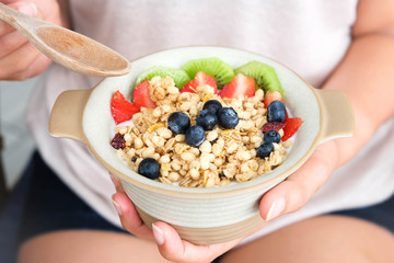 Hand of woman holding bowl of fresh strawberry and yogurt .Concept of healthy diet and weight control