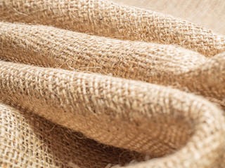 Brown sackcloth. Crumpled burlap textile, close up view. Texture of brown burlap. Crumpled baline, an abstract background. Selective soft focus. Blurred background