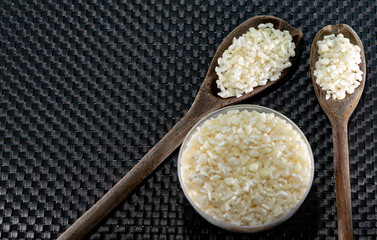 Hominy corn served in bowl and wooden spoons on a dark background