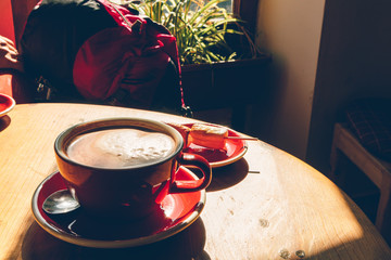 Cup of hot coffee with low sunlight from the windows.