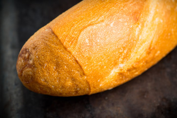 Freshly baked baguette bread on the rustic background. Selective focus. Shallow depth of field.