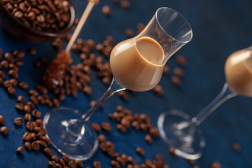 Irish cream or Coffee Liqueur and coffee beans on blue background