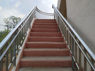 Stairs of overpass and stainless steel railings for people to walk cross the road for safety.