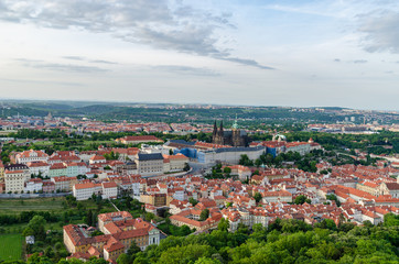 Fototapeta na wymiar Orange color roof houses with St Vitus Cathedral in the background in Prague Czech Republic