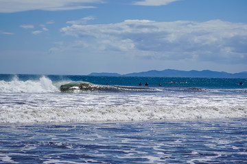 Beautiful aerial view of surfers surfing in Naranjo Beach 