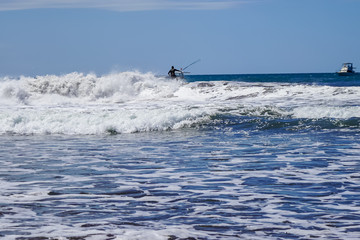 Beautiful aerial view of surfers surfing in Naranjo Beach 