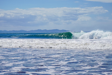 Beautiful aerial view of surfers surfing in Naranjo Beach 