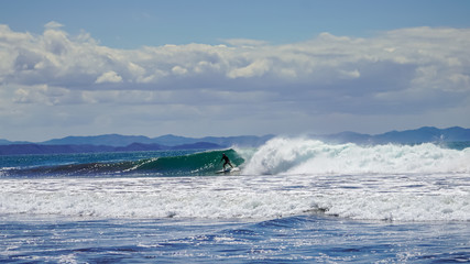 Beautiful aerial view of surfers surfing in Naranjo Beach 