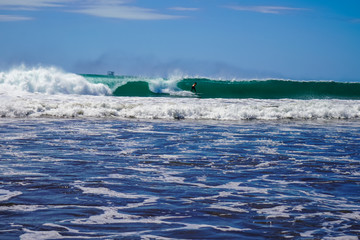 Beautiful aerial view of surfers surfing in Naranjo Beach 