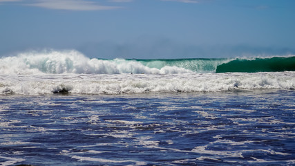 Beautiful aerial view of surfers surfing in Naranjo Beach 