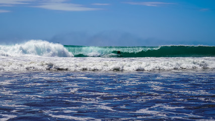 Beautiful aerial view of surfers surfing in Naranjo Beach 