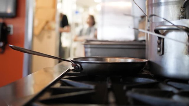 Chef adds pinch of salt into pan on gas grill in a classic 'Salt Bae' motion
