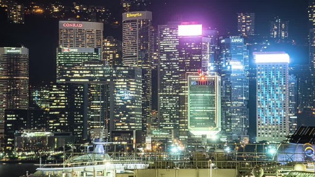 Day to night transition time lapse of Hong Kong downtown. Timelapse of HK financial district and near Central in downtown at nighttime. Harbor with boats and ferries lit up until morning daybreak.