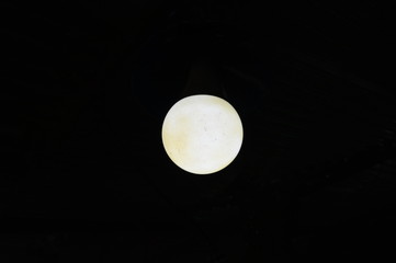 The brightness of an unclean circular lamp on a completely dark background Look like the moon . The concept of light in the dark