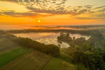 Naklejka na ściany i meble Germany, a powerful sunrise over a misty lake, pure nature moment.