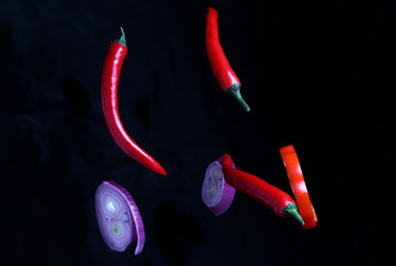 natural vegetable spices made from hot and sweet peppers and onions hung on a dark background