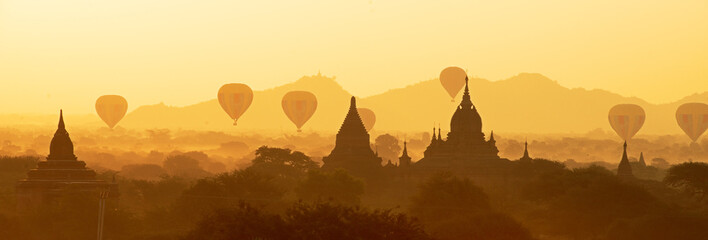 Scenic and stunning sunrise with many hot air balloons over Bagan in Myanmar. Bagan is an ancient...