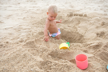 cute little girl playing with sand on tropical beach