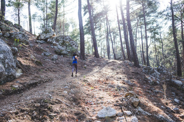 Obraz premium A woman runs along a mountain trail.
