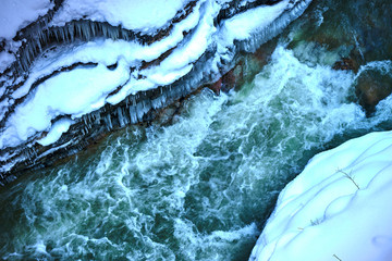The mountain river in a frozen rocky canyon.