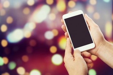 Human hands hold the smartphone with a blank screen