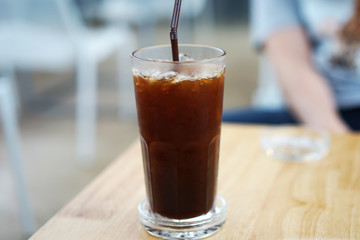 Close up glass of iced black Americano coffee on wooden table