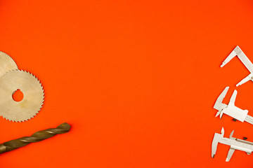 The concept on the theme of metal-cutting and insulating tools. On a bright orange background, disk...