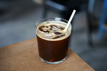 Close up glass of iced black Americano coffee on wooden table