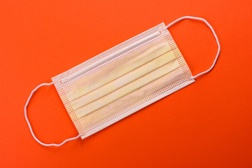 Medical mask on a colored background, a means of protection against coronovirus and epidemic