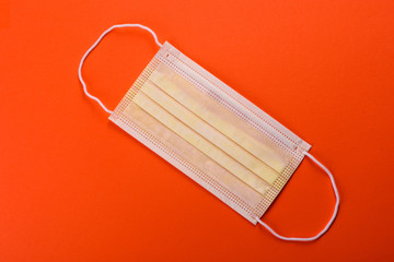 Medical mask on a colored background, a means of protection against coronovirus and epidemic