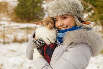 Woman hug warming her little dog in winter